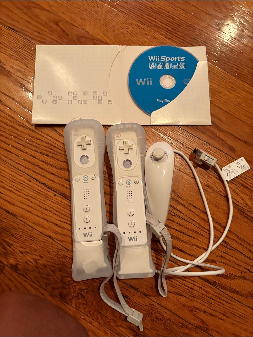 Nintendo White Wii Remote Controllers with Nunchuk and Blue Wii Sports Disc